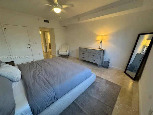 a spacious bedroom with a bed and a chandelier