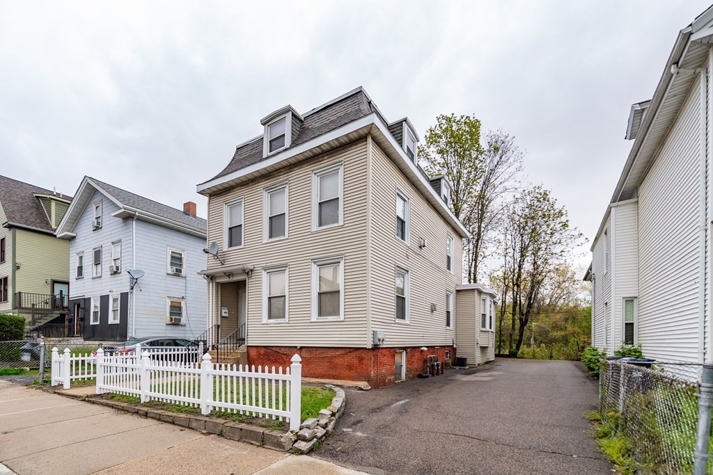 23 Marcella Street, Unit 2 Boston, MA 02119 - Photo 1 of 26 a front view of a house with a yard and garage