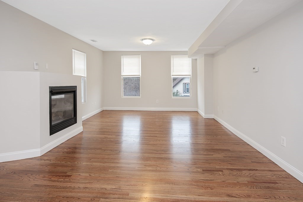 23 Marcella Street, Unit 2 Boston, MA 02119 - Photo 2 of 26 an empty room with wooden floor and windows