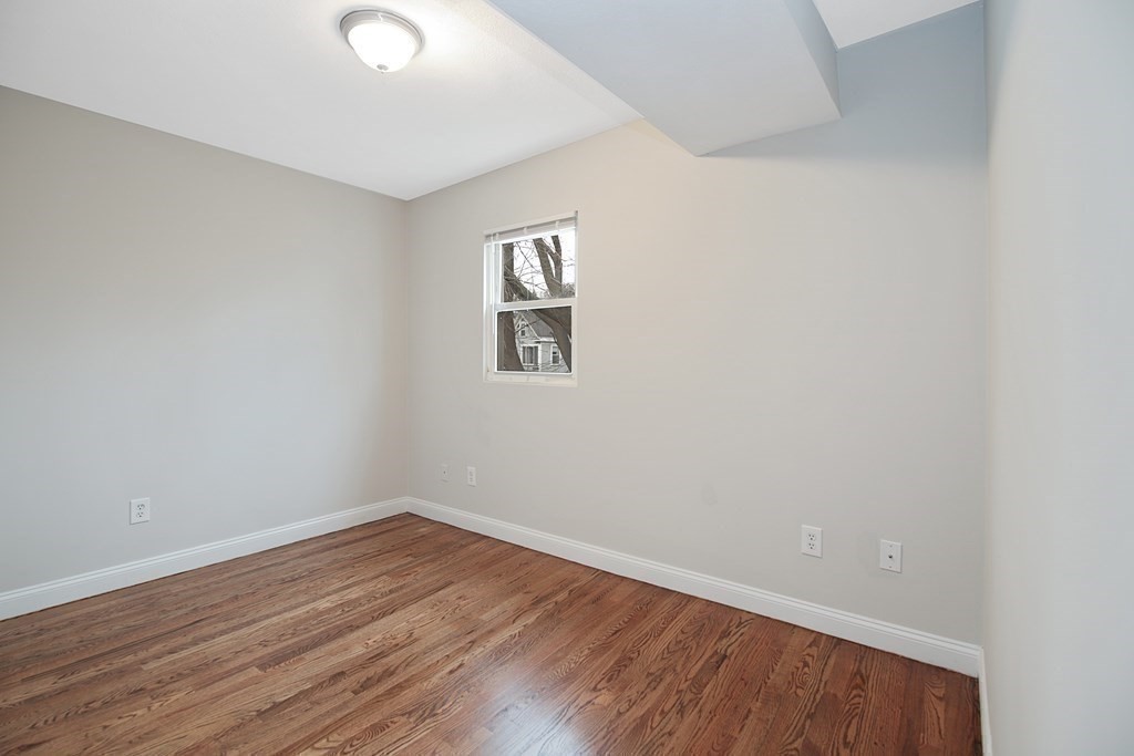23 Marcella Street, Unit 2 Boston, MA 02119 - Photo 21 of 26 an empty room with wooden floor and windows