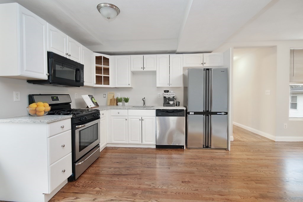 23 Marcella Street, Unit 2 Boston, MA 02119 - Photo 3 of 26 a kitchen with stainless steel appliances granite countertop a refrigerator sink and white cabinets