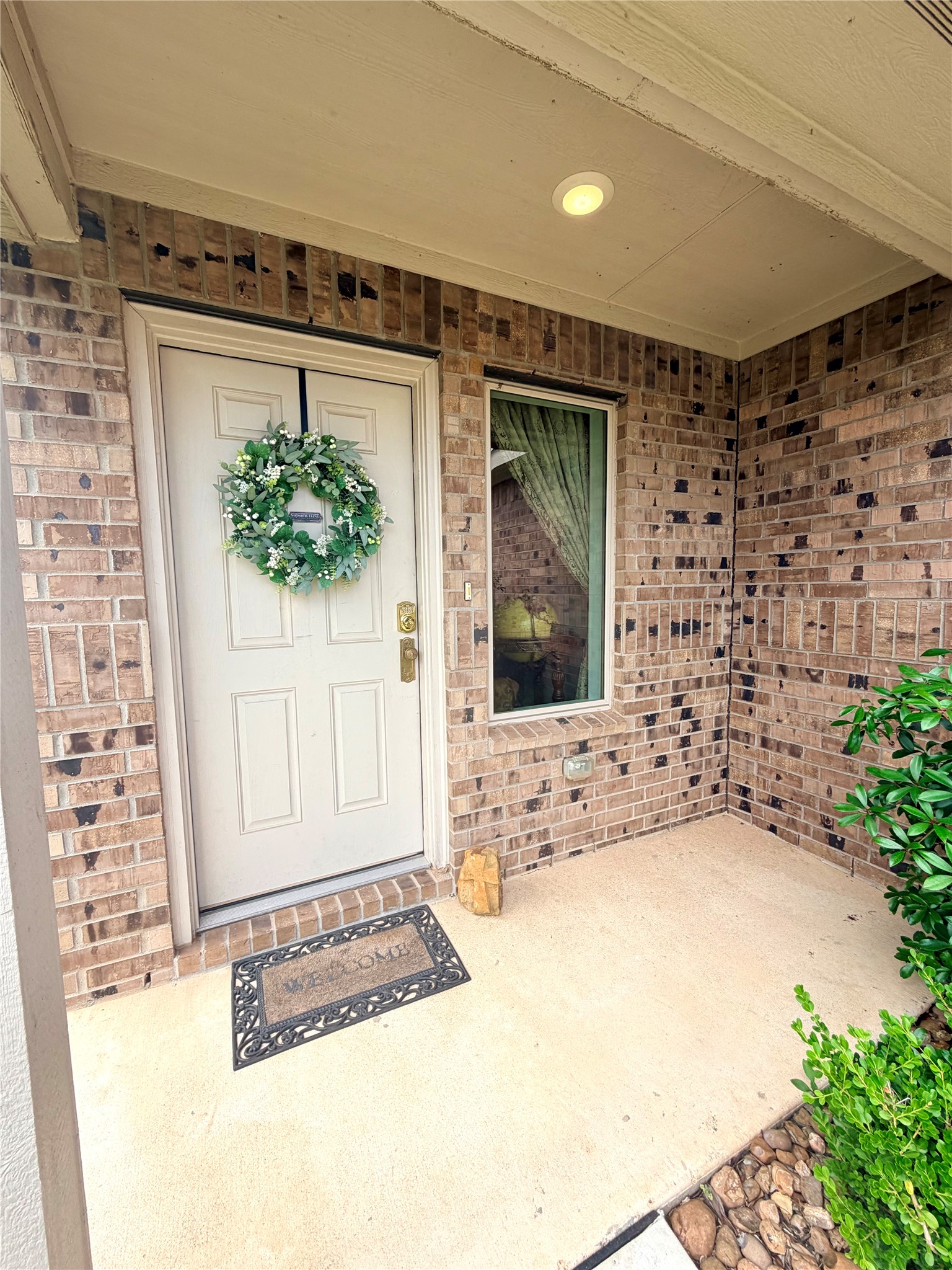 532 Flower Reed Court Magnolia, TX 77354 - Photo 4 of 43 This inviting entryway features a covered porch with warm brick, a welcoming white door, and a window for natural light!