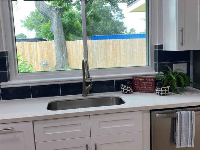a kitchen with a sink a counter and a large window
