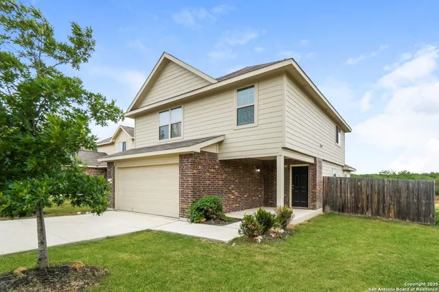a front view of a house with a garden and yard