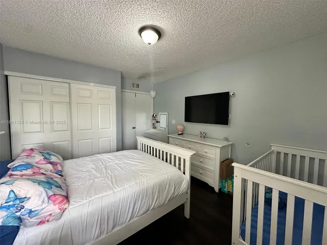 a bedroom with a bed and flat screen tv