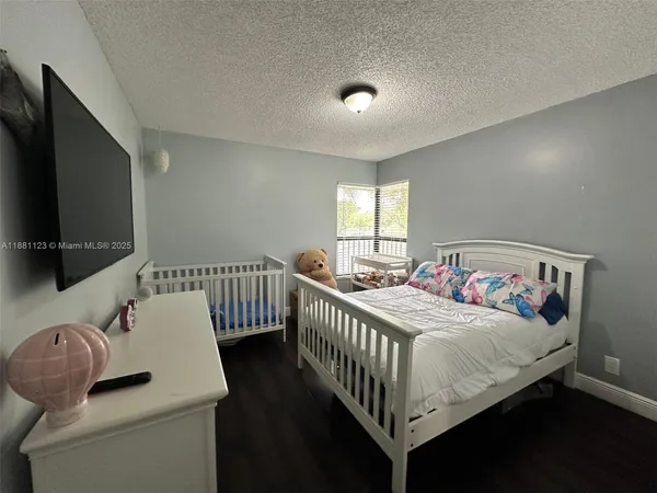 a bedroom with bed and a flat screen tv