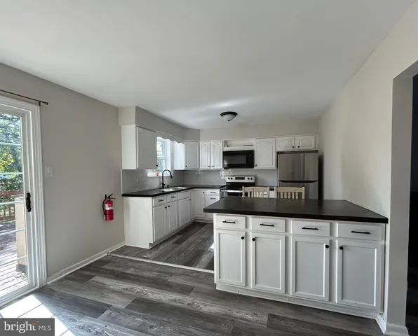 a kitchen with granite countertop a sink cabinets and stainless steel appliances