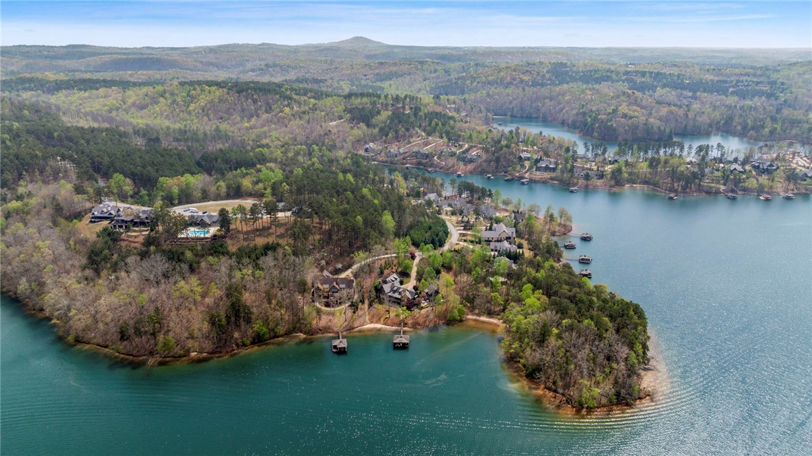 195 Village View Drive Sunset, SC 29685 - Photo 48 of 48 This aerial view showcases a vibrant community nestled along a picturesque lake, surrounded by lush, rolling hills.