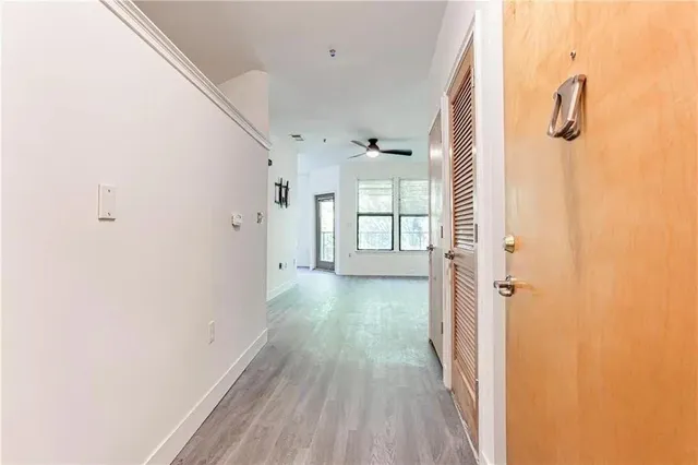 a view of a hallway with wooden floor and closet