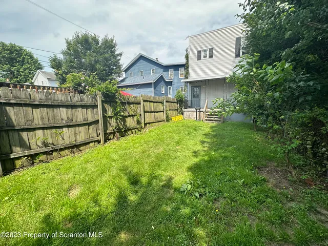 a view of backyard with a garden and deck