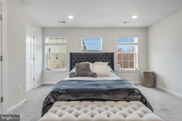 a large bedroom with a bed and window