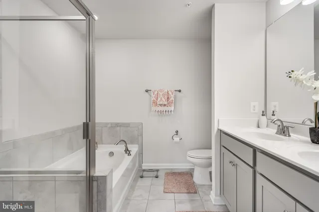 a bathroom with a granite countertop sink a toilet and shower