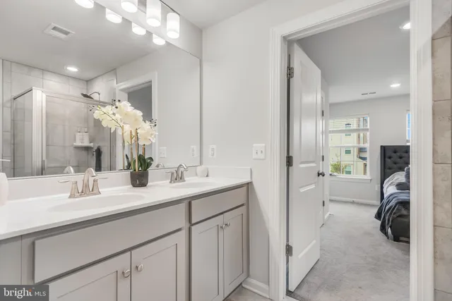 a en suite bathroom with a double vanity sink mirror and shower