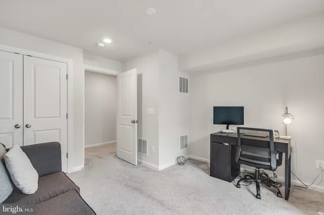 a view of a workspace with furniture and a window