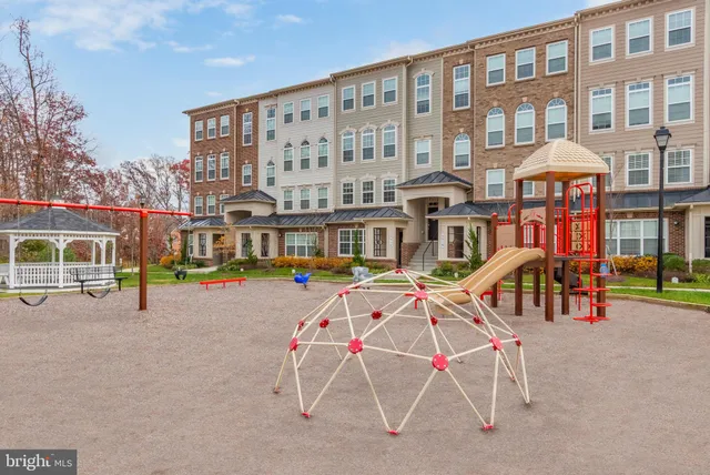 a view of a brick building with a bench and chairs