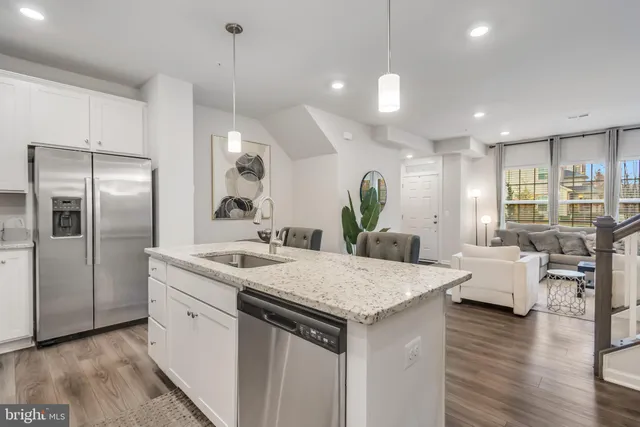 a kitchen with stainless steel appliances granite countertop a sink refrigerator and wooden floor