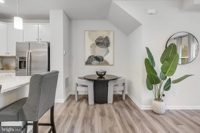 a kitchen with stainless steel appliances a dining table cabinets and wooden floor