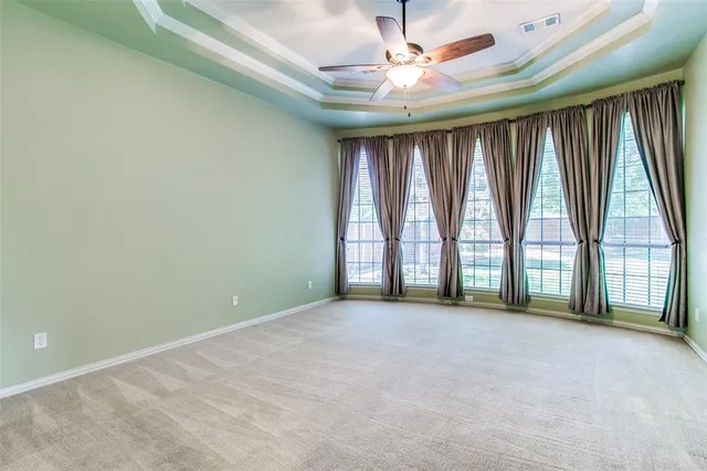 an empty room with windows and a ceiling fan