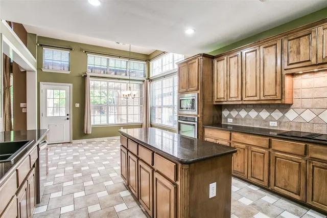a kitchen with stainless steel appliances granite countertop a stove a sink and a refrigerator