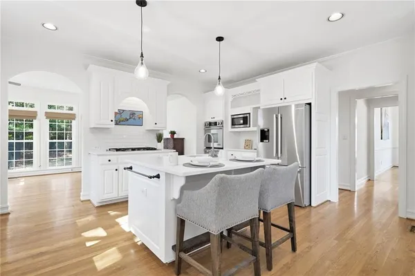 a large white kitchen with cabinets a sink and appliances