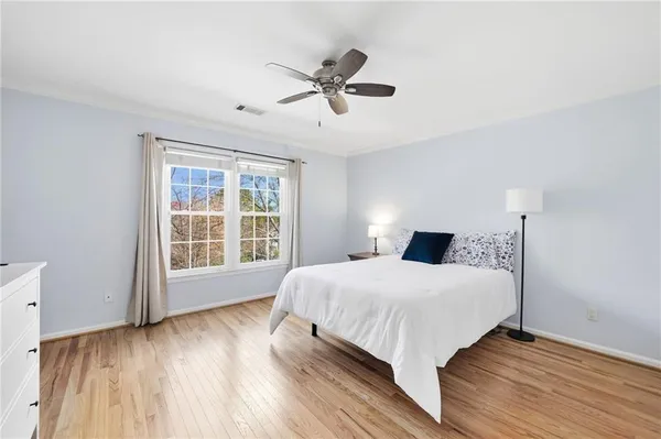 a bedroom with a large bed and a potted plant