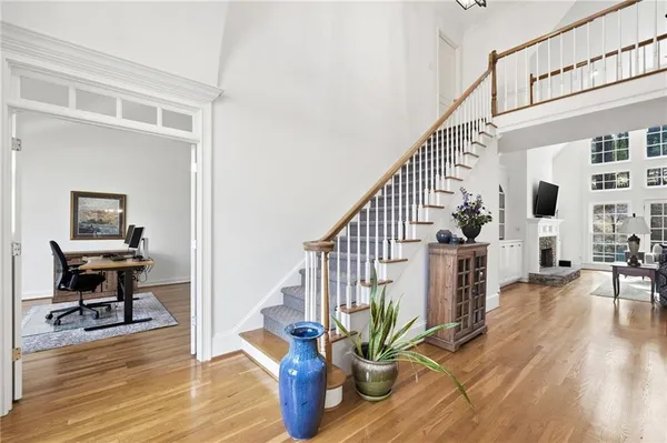 a view of a hallway with dining room and wooden floor