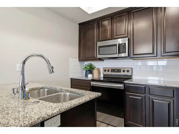 a kitchen with granite countertop a sink and stainless steel appliances