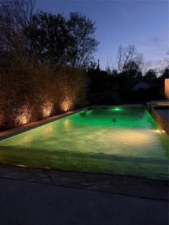 a view of a swimming pool with a yard and outdoor seating