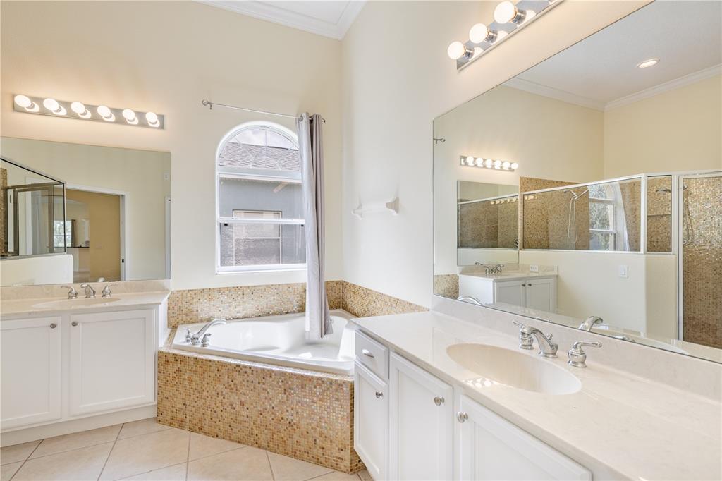 2718 Knightsbridge Road Clermont, FL 34711 - Photo 7 of 72 a bathroom with a granite countertop bathtub sink and mirror