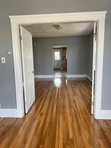 a view of empty room with wooden floor