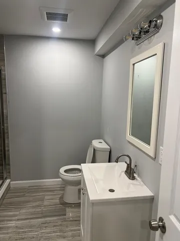 a bathroom with a toilet sink and mirror