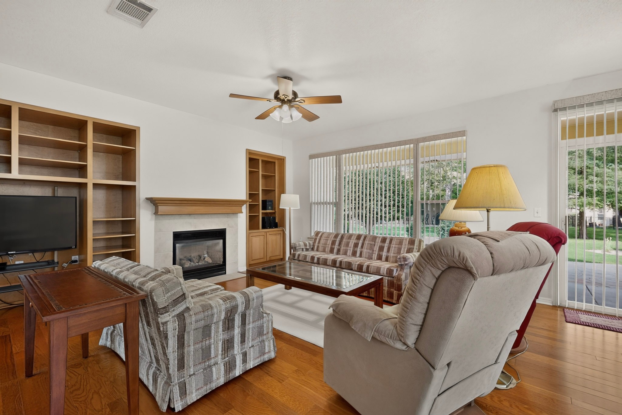 207 Red Poppy Trail Georgetown, TX 78633 - Photo 5 of 31 Hardwood floors and a cozy fireplace anchor this inviting living space with built-in shelving.