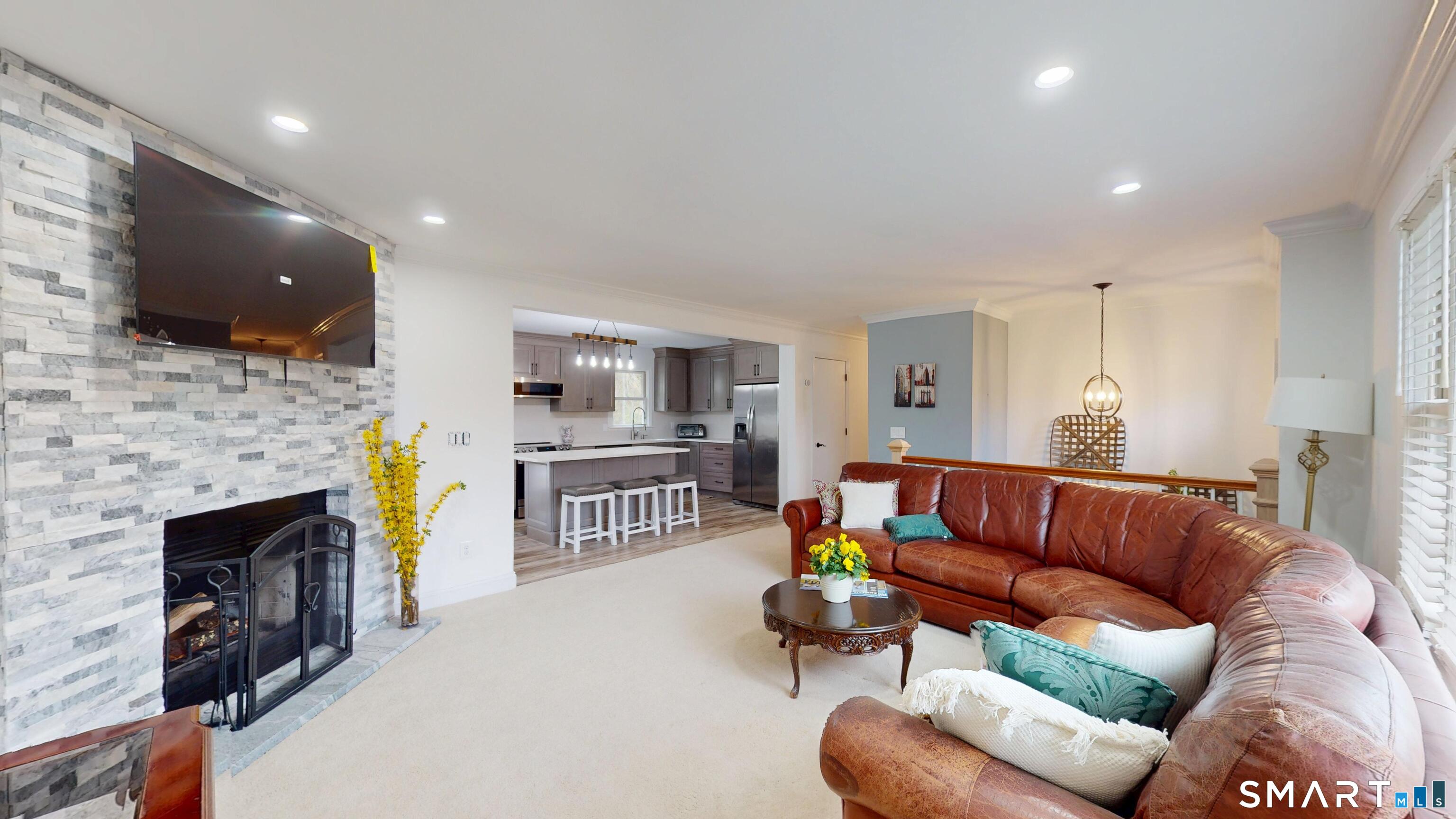 29 Deer Ridge Road Stonington, CT 06378 - Photo 5 of 35 a living room with furniture a flat screen tv and a fireplace