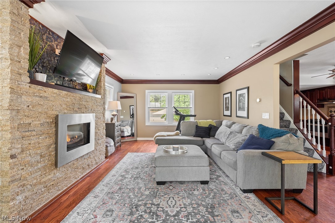 3625 Cedarbrook Road Cleveland, OH 44118 - Photo 3 of 15 A modern veneer stone electric fireplace commands attention in the living room, framed by large picture windows showcasing nature's beauty.
