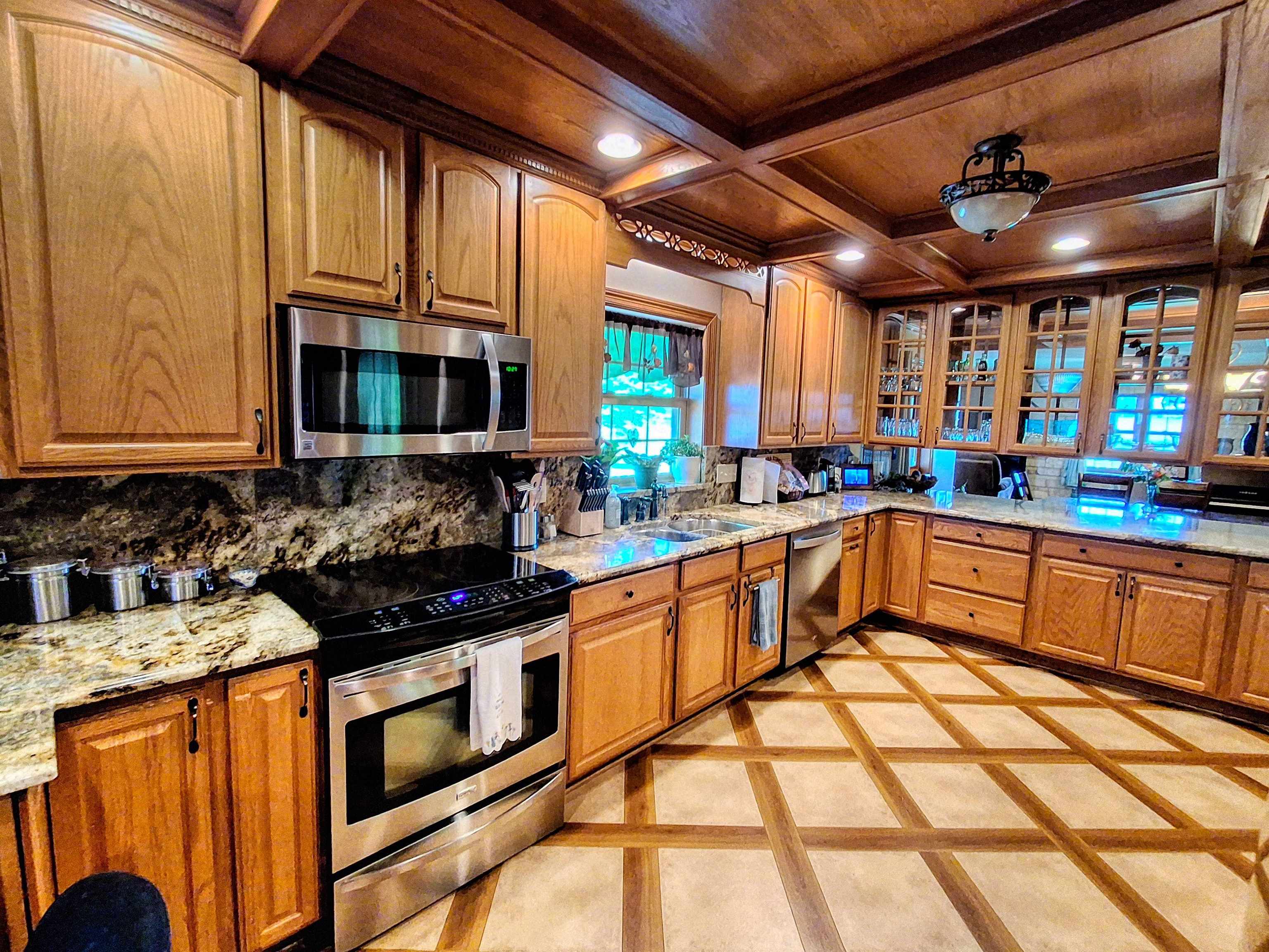 7009 West Pearl City Road Freeport, IL 61032 - Photo 4 of 35 a kitchen with stainless steel appliances granite countertop wooden cabinets a stove top oven a sink and dishwasher a oven with granite countertops