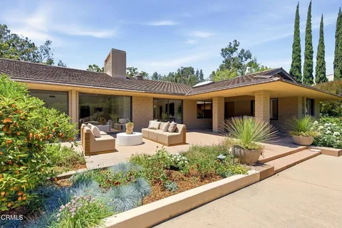 a front view of a house with porch and outdoor seating