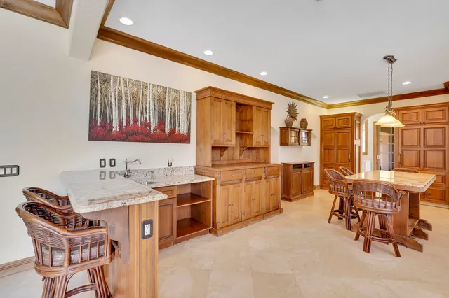 a dining table with chairs and kitchen view