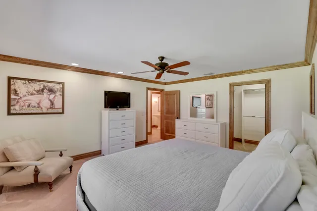 a spacious bedroom with a bed a couch and dresser