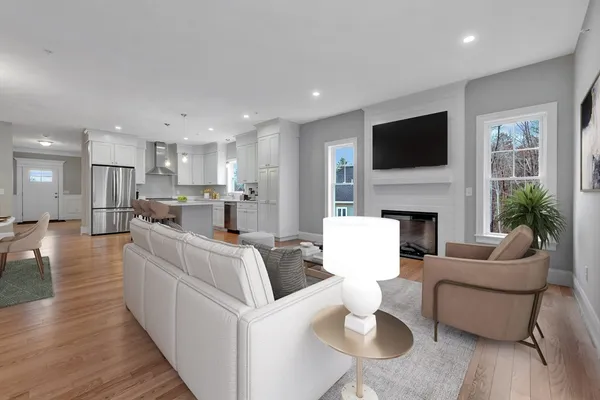 an empty room with wooden floor fireplace and windows