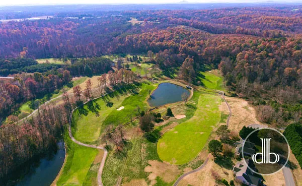 an aerial view of a swimming pool with outdoor seating and yard