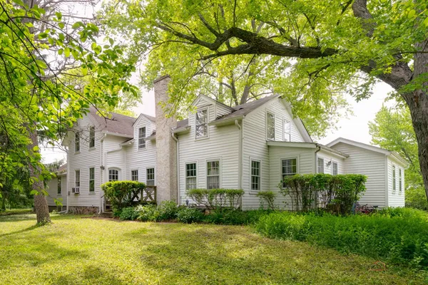 a front view of a house with a yard and trees