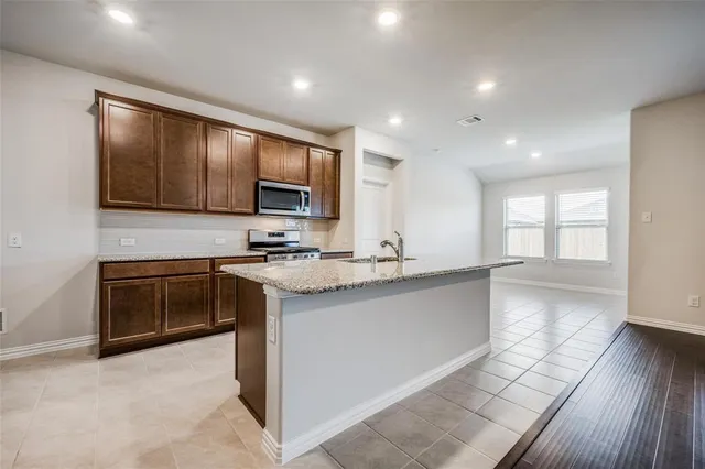 a kitchen with stainless steel appliances granite countertop a stove sink and cabinets