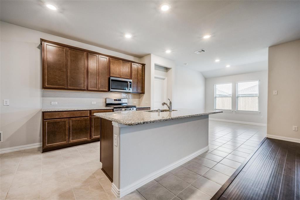 5113 Unity Drive Denton, TX 76207 - Photo 12 of 22 a kitchen with stainless steel appliances granite countertop a stove sink and cabinets