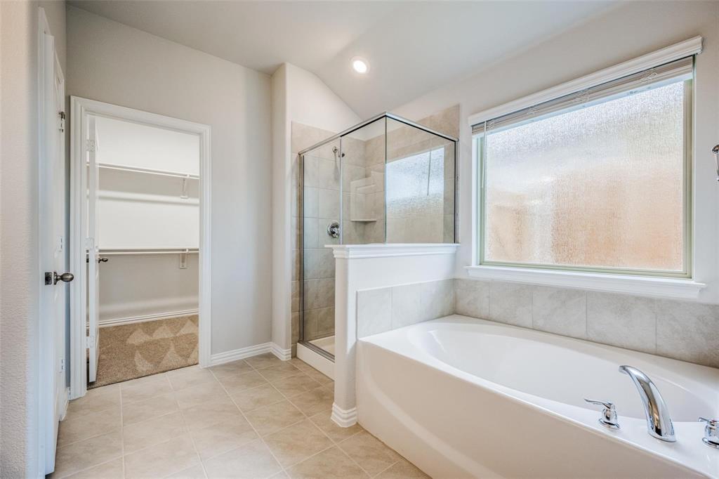 5113 Unity Drive Denton, TX 76207 - Photo 17 of 22 a bathroom with a bathtub and a shower