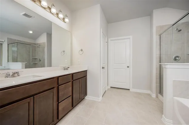 a spacious bathroom with a double vanity sink mirror and shower