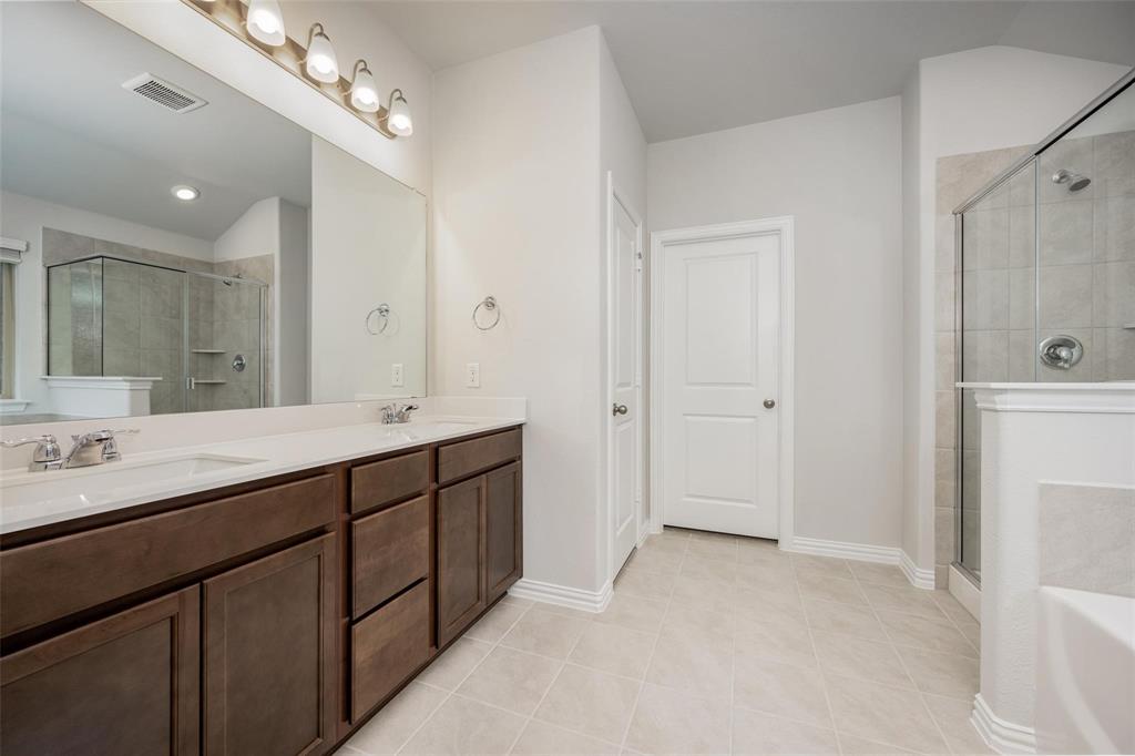 5113 Unity Drive Denton, TX 76207 - Photo 18 of 22 a spacious bathroom with a double vanity sink mirror and shower