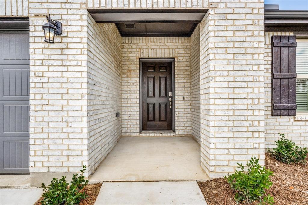 5113 Unity Drive Denton, TX 76207 - Photo 2 of 22 a front view of a house with potted plants