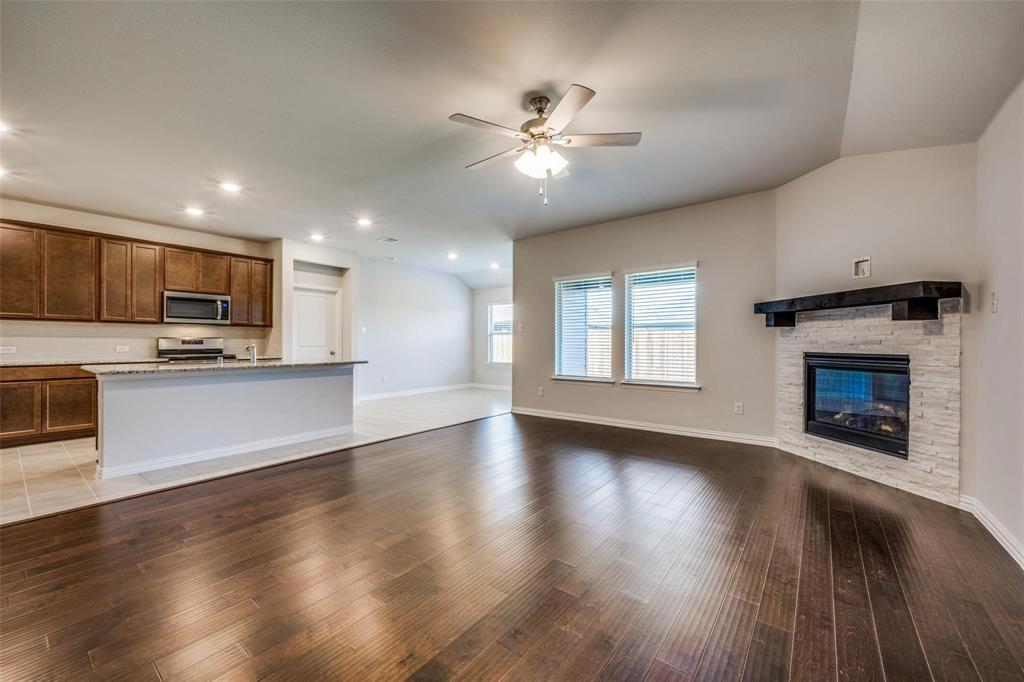 5113 Unity Drive Denton, TX 76207 - Photo 8 of 22 a view of an empty room with kitchen and a fireplace