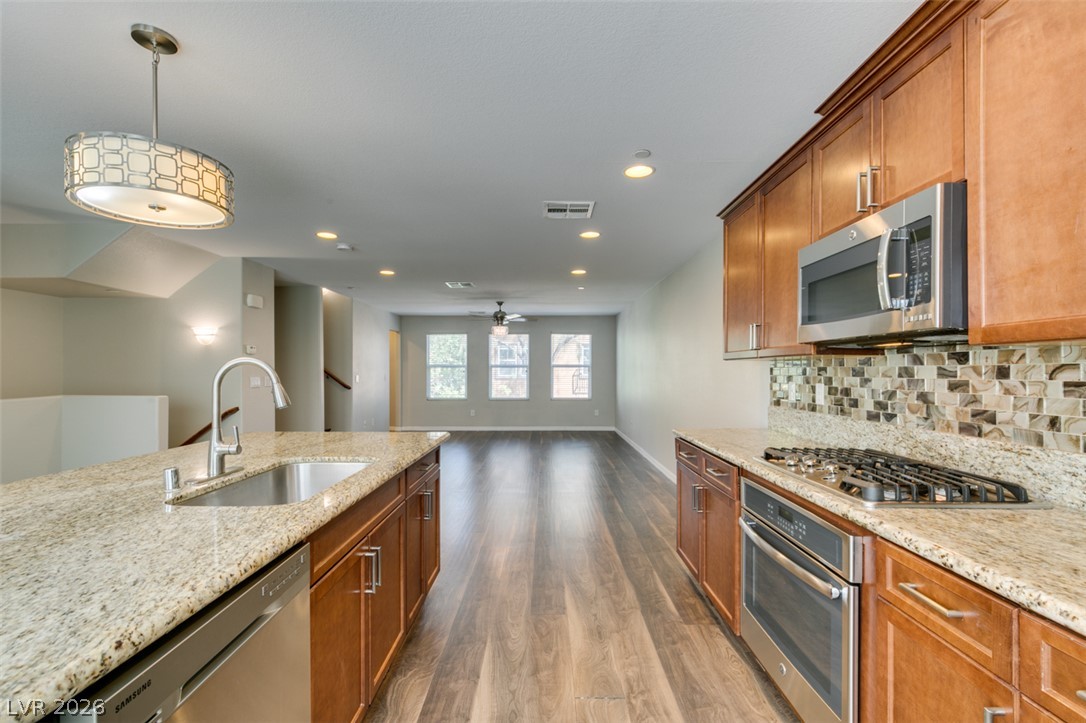 4650 Ranch House Road, Unit 46 North Las Vegas, NV 89031 - Photo 21 of 38 Gleaming stone countertops and classic wood cabinetry enrich this seamless, open-concept kitchen space.