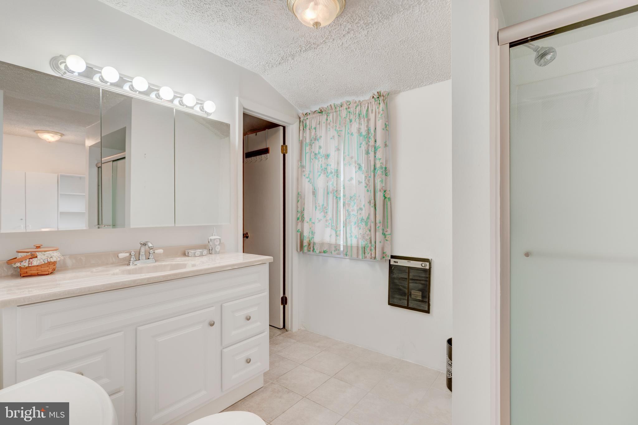 3402 Offutt Road Randallstown, MD 21133 - Photo 29 of 63 a spacious bathroom with a double vanity sink a mirror and shower